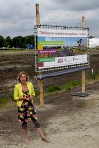 Titia Wolterbeek bij een banier in Soet op Suyt. Op de achtergrond een ingezaaide honingweide (foto: Kars Veling)